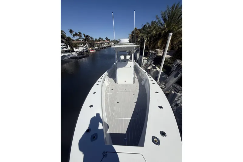 Slide: The Image of 2015 Conch 27 boat on water, surrounded by palm trees and other boats. - 5