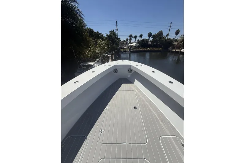 Slide: The Image of 2015 Conch 27 boat docked on a calm waterfront with palm trees. - 6