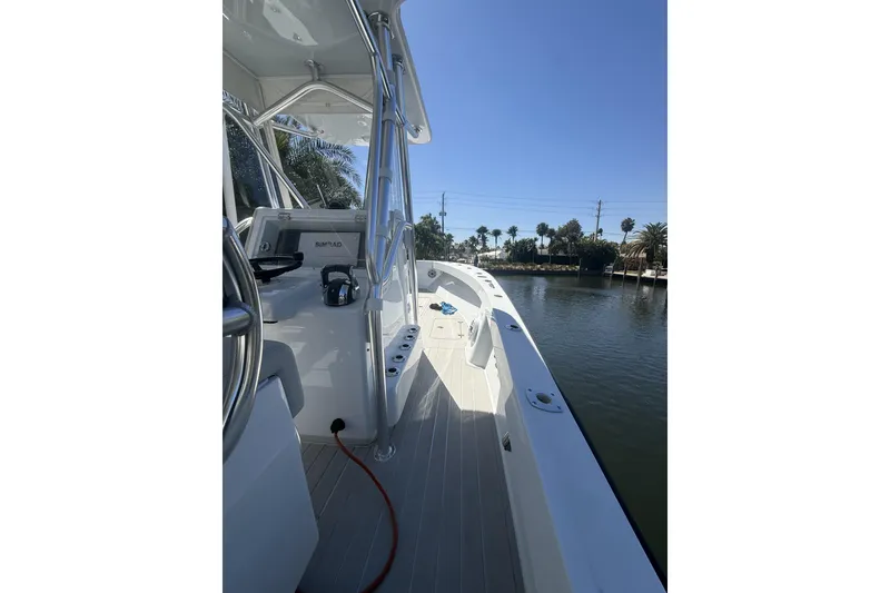 Slide: The Image of 2015 Conch 27 boat with dual 400 horsepower engines docked by a waterfront home. - 7