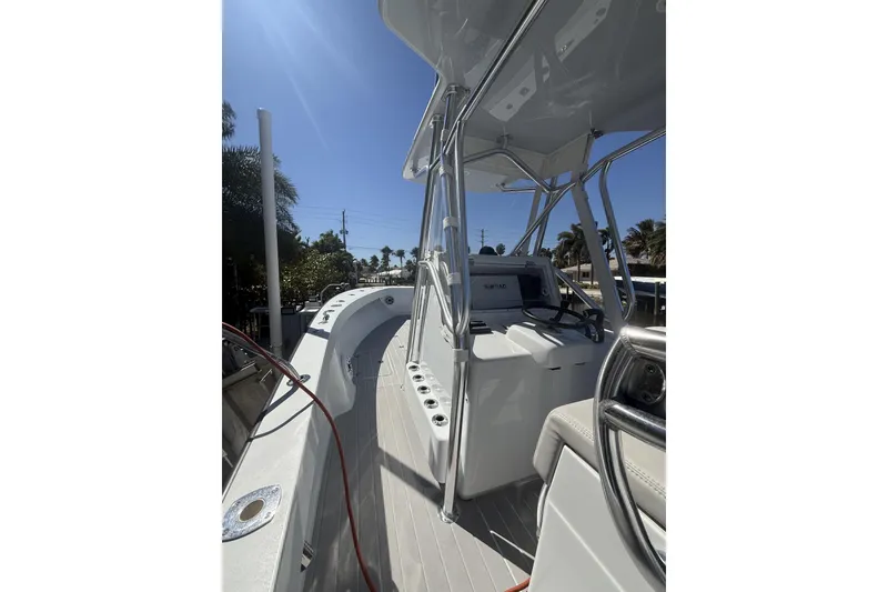 Slide: The Image of 2015 Conch 27 boat docked in a marina with palm trees in the background. - 8