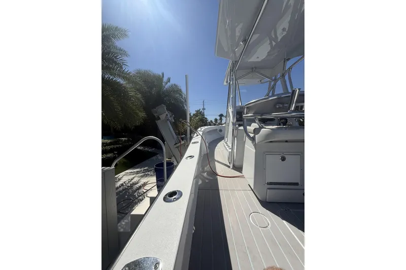 Slide: The Image of 2016 Conch 27 boat deck with seating, under clear blue sky. - 12