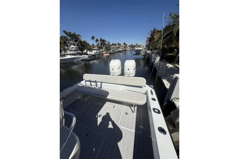 Slide: The Image of 2016 Conch 27 boat docked in a sunny marina with palm trees. - 16