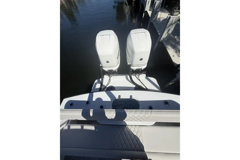 Slide: The Image of 2016 Conch 27 boat with dual outboard engines docked on calm water. - 17
