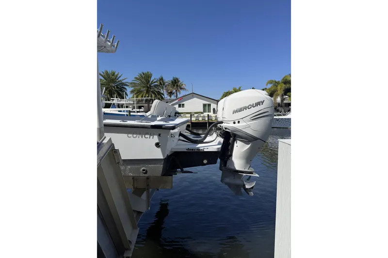 Slide: The Image of 2016 Conch 27 boat with Mercury outboard motor docked by palm trees. - 3