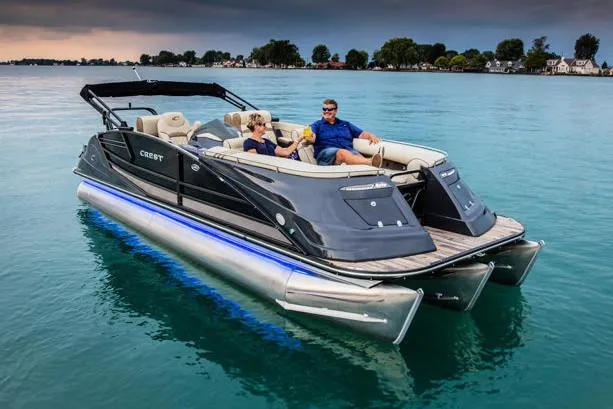 Slide: The Image of Manufacturer Provided Image: 2020 Crest Savannah 250 SLRC pontoon boat cruising on a serene lake. - 13