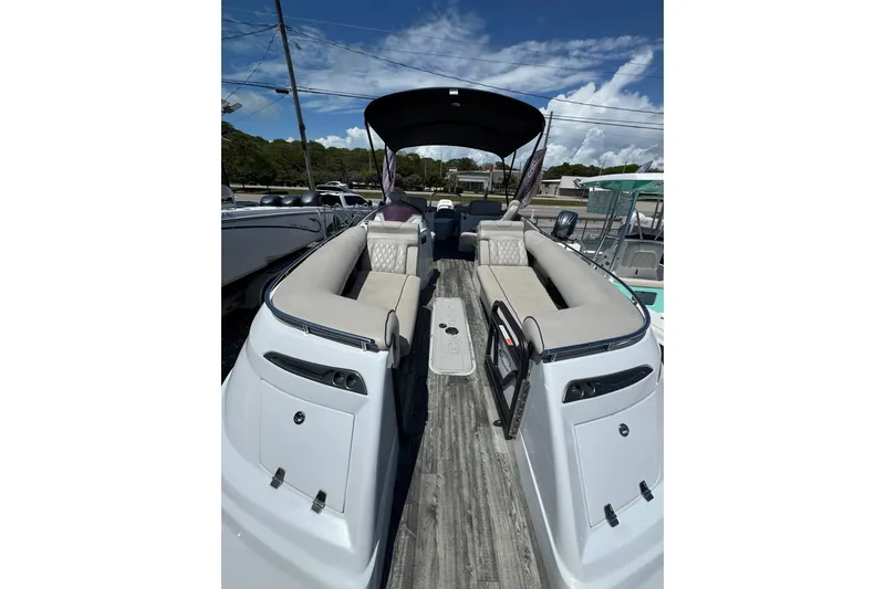 Slide: The Image of 2020 Crest Savannah 250 SLRC pontoon boat with spacious seating and canopy under a clear sky. - 4