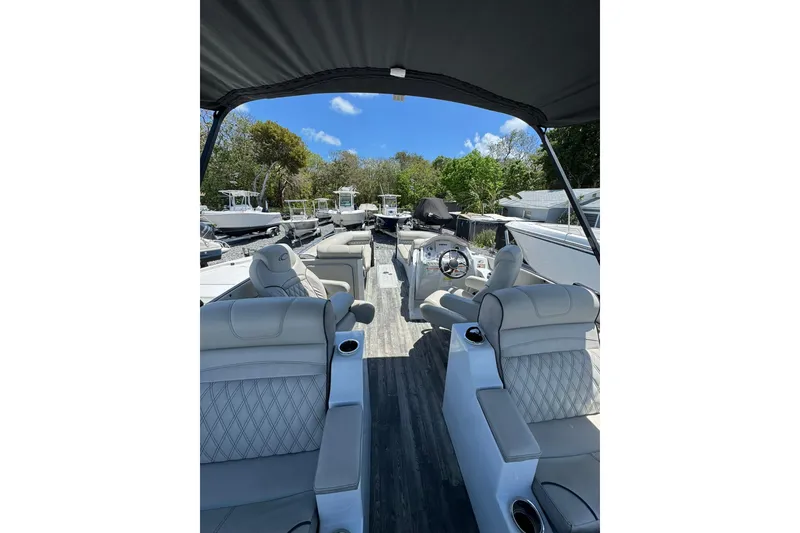 Slide: The Image of 2020 Crest Savannah 250 SLRC pontoon boat interior with luxurious seating and helm. - 7