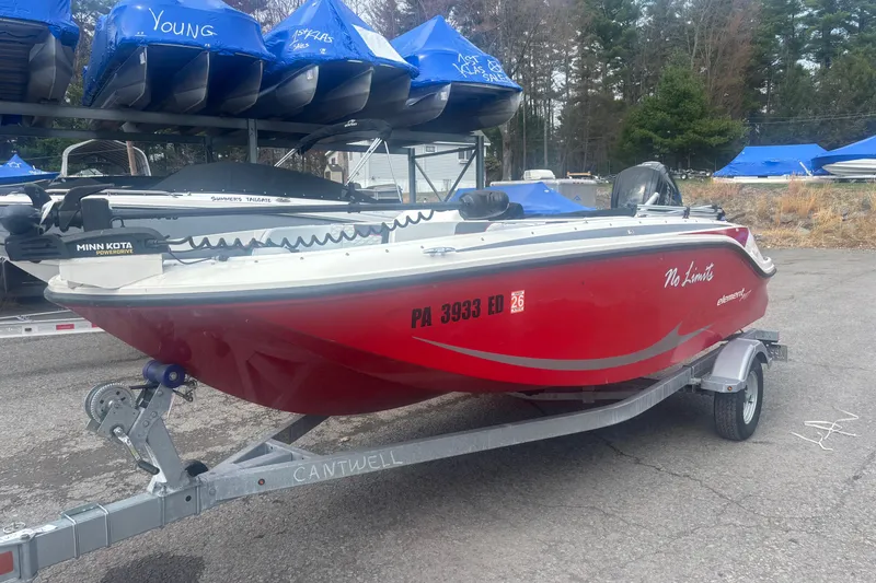 The Image of 2023 Bayliner Element E17 boat in red on a trailer, parked outdoors. - 1
