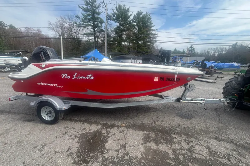 Slide: The Image of 2023 Bayliner Element E17 boat in red, parked on a trailer outdoors. - 6