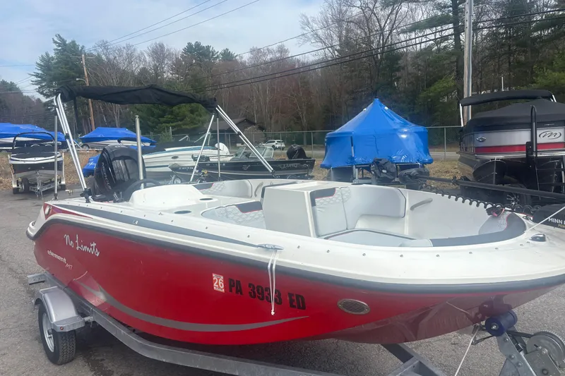 Slide: The Image of 2023 Bayliner Element E17 boat in red, parked on a trailer outdoors. - 8