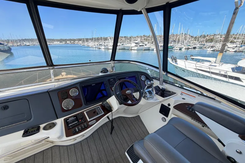 Slide: The Image of Helm of 2009 Meridian 441 Sedan yacht with marina view, featuring modern controls and navigation. - 17