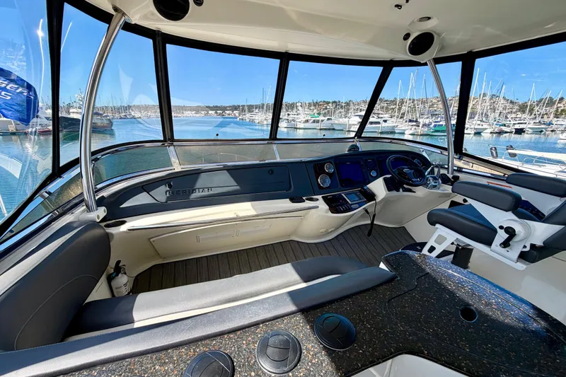 Slide: The Image of 2009 Meridian 441 Sedan yacht cockpit with marina view, featuring modern navigation equipment. - 23