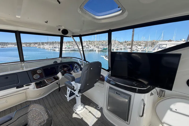 Slide: The Image of Interior view of 2009 Meridian 441 Sedan yacht helm with marina backdrop. - 24