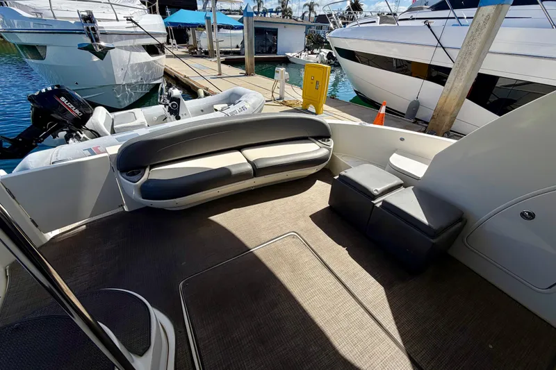 Slide: The Image of 2009 Meridian 441 Sedan yacht interior with seating area and docked boats in background. - 30