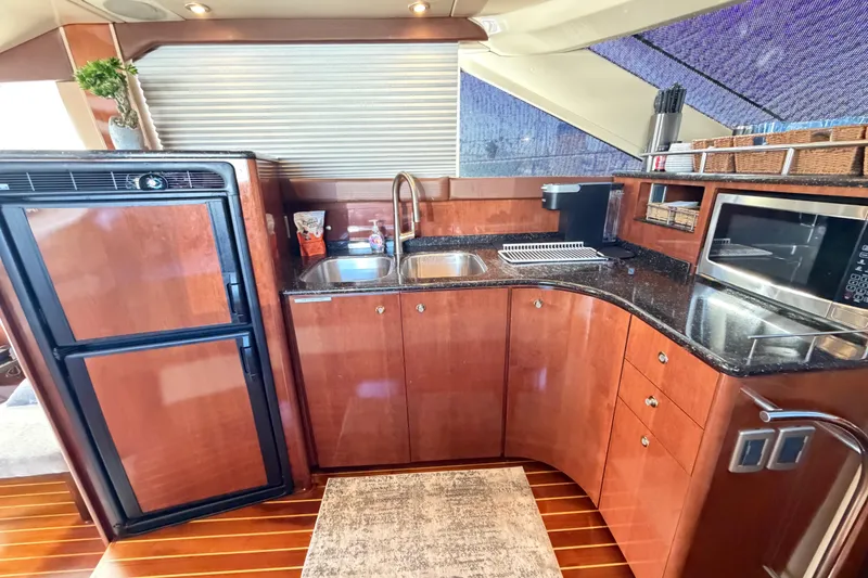 Slide: The Image of Luxurious 2009 Meridian 441 Sedan yacht kitchen with wood cabinetry and modern appliances. - 6