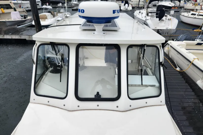 Slide: The Image of 2018 Atlas Acadia boat docked, featuring a white cabin with large windows and radar equipment. - 1