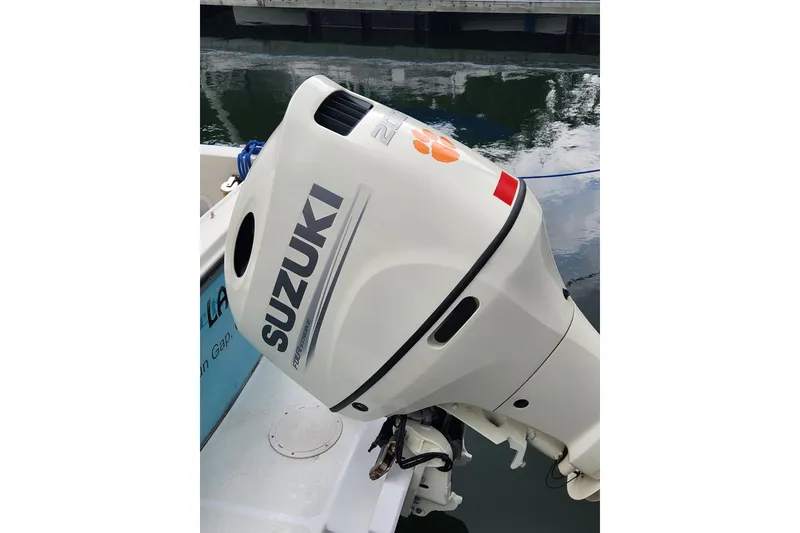 Slide: The Image of Suzuki outboard motor on a boat, reflecting in calm water. - 12