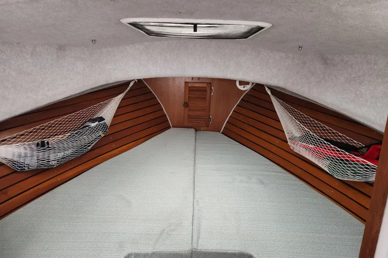 Slide: The Image of Cozy interior of a 2018 Atlas Acadia boat with wooden paneling and netted storage. - 6