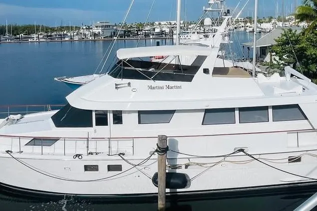 The Image of 1991 Hatteras 70 Cockpit Motor Yacht docked in a marina. - 0