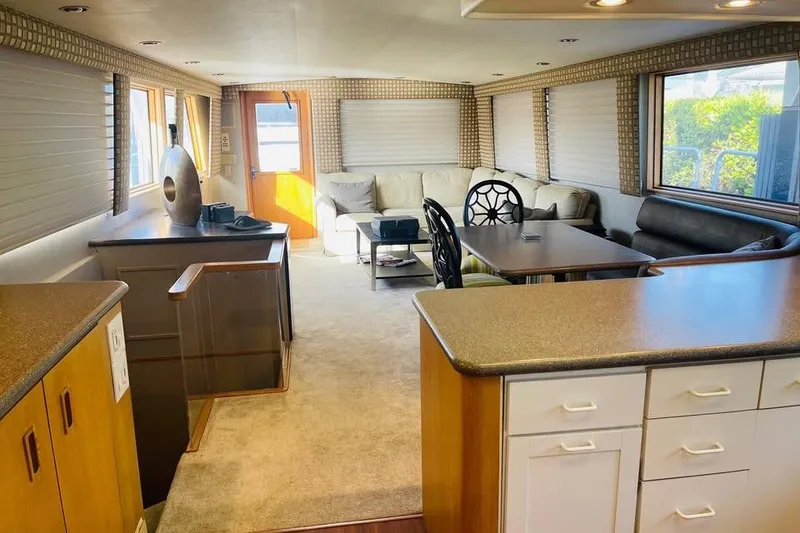 Slide: The Image of Interior of 1991 Hatteras 70 Cockpit Motor Yacht with modern furnishings and ample natural light. - 11