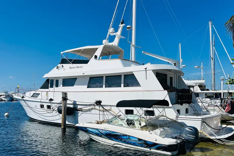 Slide: The Image of 1991 Hatteras 70 Cockpit Motor Yacht docked in a sunny marina. - 2