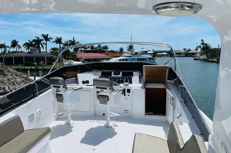 Slide: The Image of Flybridge of 1991 Hatteras 70 Cockpit Motor Yacht with dual helm seats, overlooking marina. - 21