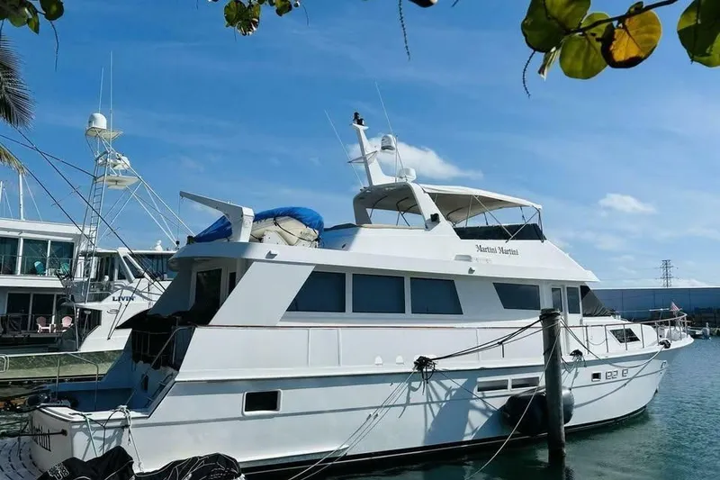 Slide: The Image of 1991 Hatteras 70 Cockpit Motor Yacht docked in a sunny marina setting. - 22