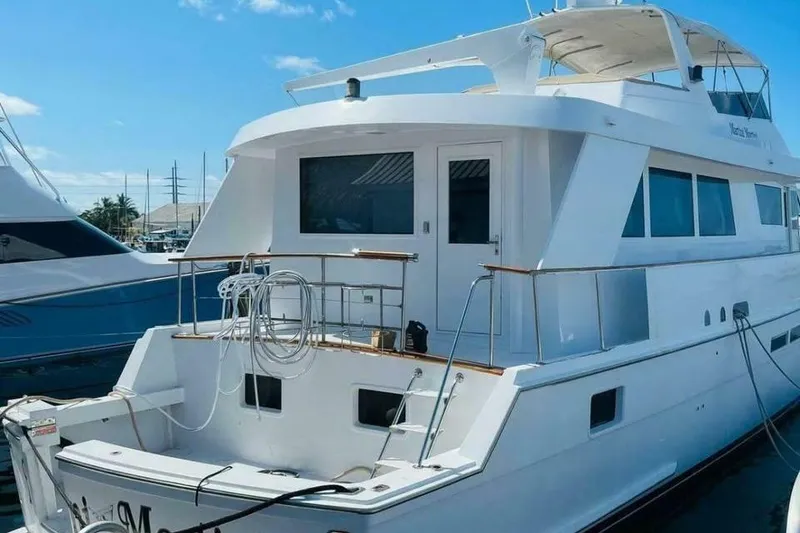 Slide: The Image of 1991 Hatteras 70 Cockpit Motor Yacht docked under clear blue sky. - 24
