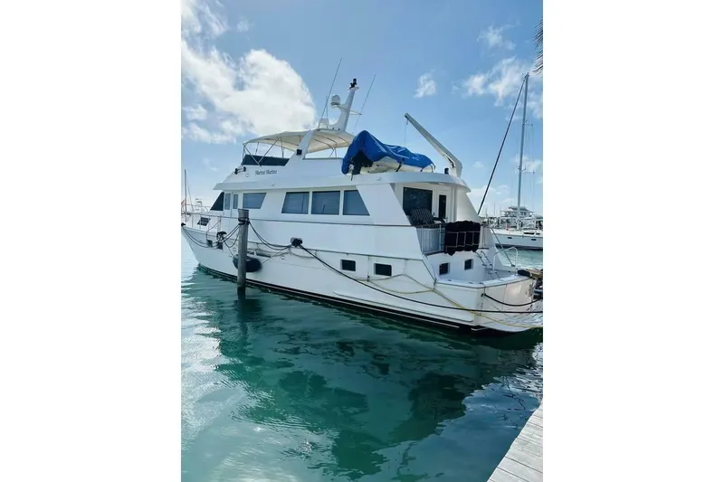 Slide: The Image of 1991 Hatteras 70 Cockpit Motor Yacht docked in sunny marina. - 27