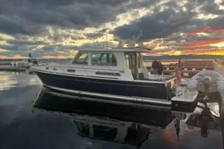 The Image of 2020 Sabre 42 Salon Express yacht docked at sunset with dramatic clouds. - 0