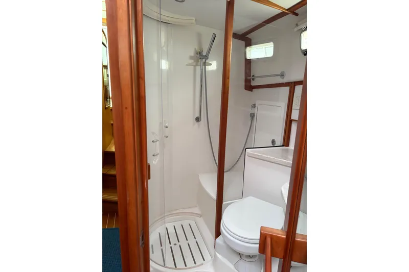 Slide: The Image of 2020 Sabre 42 Salon Express bathroom with shower, toilet, and wooden accents. - 17