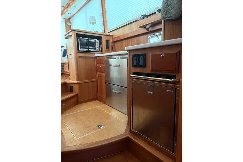 Slide: The Image of Interior of 2020 Sabre 42 Salon Express yacht, featuring modern kitchen appliances and wood cabinetry. - 7
