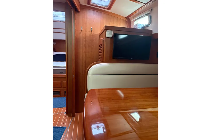 Slide: The Image of 2020 Sabre 42 Salon Express interior with wood finish, TV, and seating area. - 9