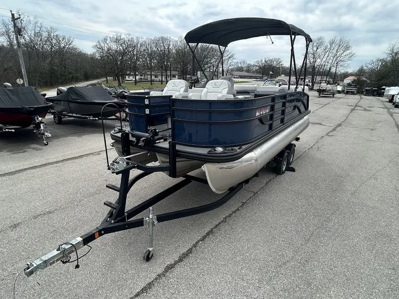 Slide: The Image of 2024 Lowe SS214 pontoon boat on trailer, parked outdoors. - 4