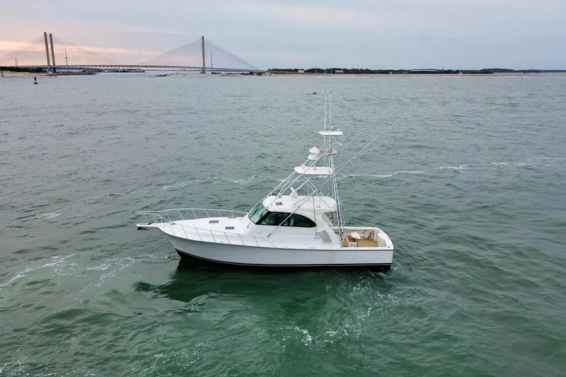 Slide: The Image of 2016 Henriques 42 Express Hardtop boat on open water near a bridge. - 5