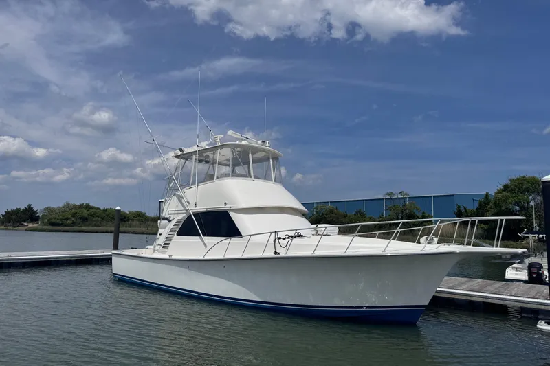Slide: The Image of 2011 Henriques 42 Flybridge yacht docked under a clear blue sky. - 1