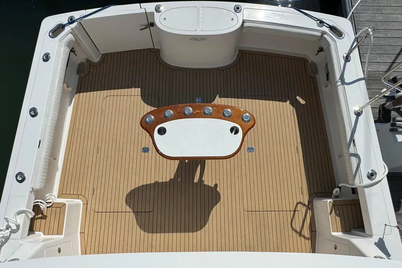 Slide: The Image of Henriques 42 Flybridge 2011 boat deck with wooden flooring and central table. - 15