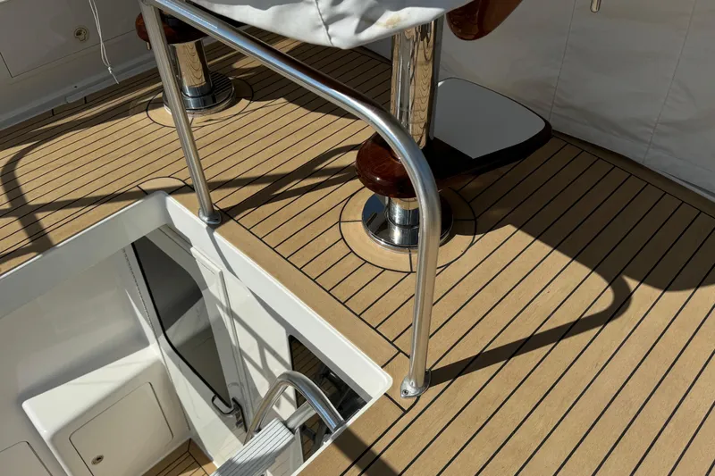Slide: The Image of Henriques 42 Flybridge 2011 boat deck with polished metal railings and wooden flooring. - 17