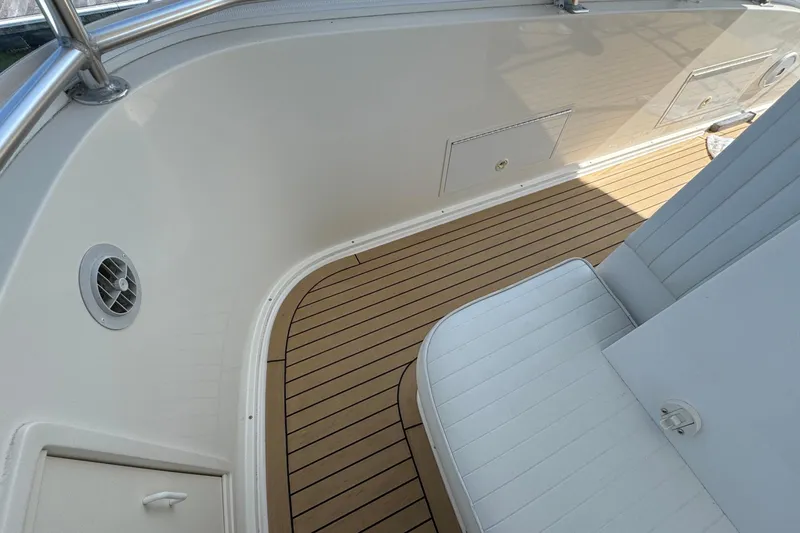 Slide: The Image of 2011 Henriques 42 Flybridge boat interior with teak flooring and white seating. - 19