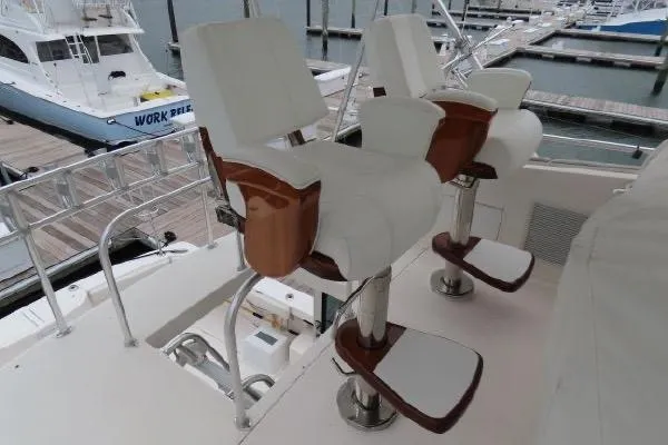 Slide: The Image of Henriques 42 Flybridge 2011 yacht with white cushioned helm chairs at marina. - 23