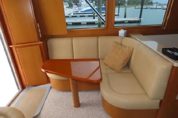 Slide: The Image of Interior of 2011 Henriques 42 Flybridge with beige seating and wooden table. - 5