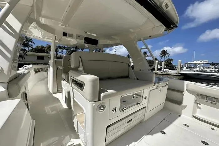 Slide: The Image of 2019 Boston Whaler 350 Realm interior with seating, docked under clear blue sky. - 12
