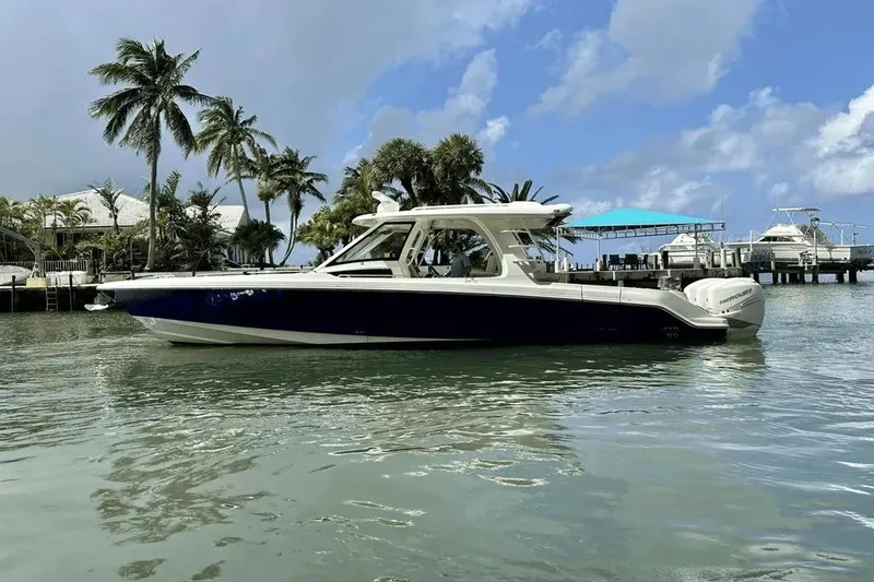 Slide: The Image of 2019 Boston Whaler 350 Realm boat on tropical water with palm trees in background. - 2
