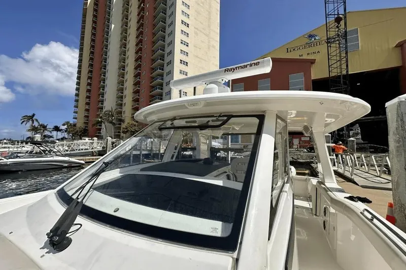 Slide: The Image of 2019 Boston Whaler 350 Realm docked at marina with tall buildings in background. - 4