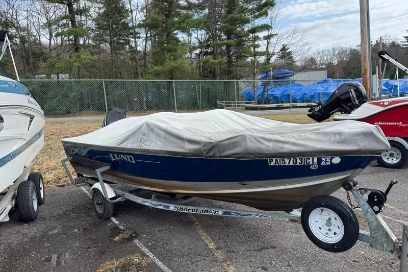 Slide: The Image of 2002 Lund 1650 Explorer SS boat covered on trailer, parked outdoors. - 10