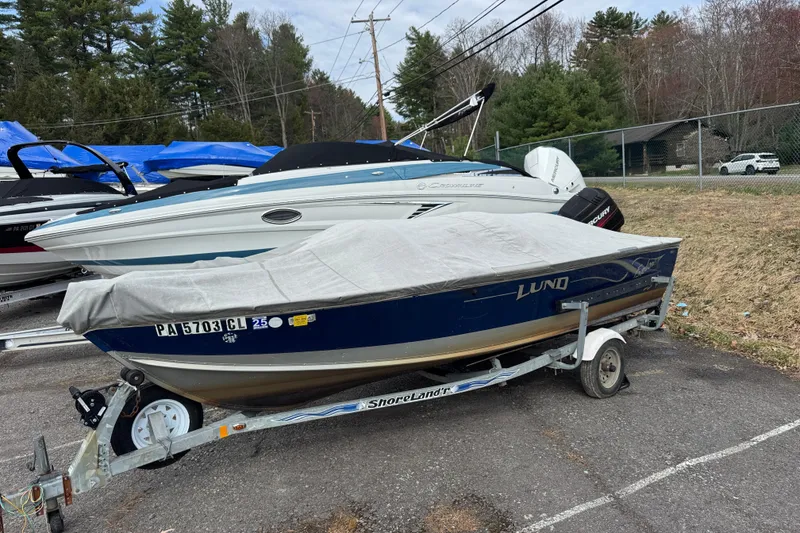 The Image of 2002 Lund 1650 Explorer SS boat on trailer, covered, parked outdoors. - 2