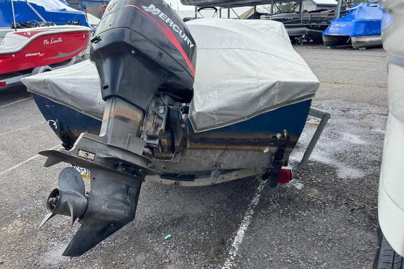 Slide: The Image of Covered 2002 Lund 1650 Explorer SS boat with Mercury outboard motor in a parking lot. - 9