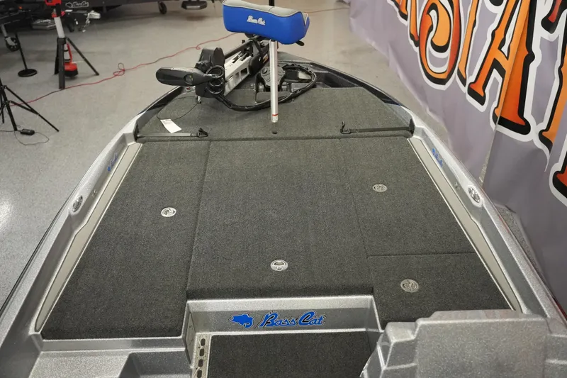 Slide: The Image of 2026 Bass Cat Lynx STS boat deck with carpeted surface and fishing equipment. - 13