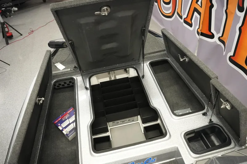 Slide: The Image of 2026 Bass Cat Lynx STS boat storage compartments with open lids and organized interior layout. - 17