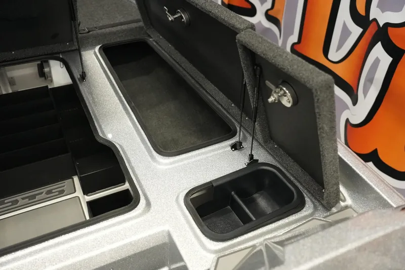 Slide: The Image of 2026 Bass Cat Lynx STS boat storage compartments with open lids and organized interior. - 19